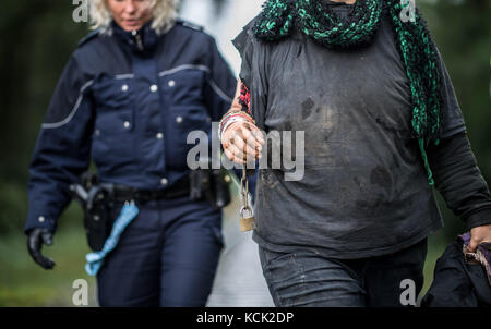 Ochtrup, Allemagne. 6 octobre 2017. Un militant opposé à la colère nucléaire est escorté hors de la voie ferrée par un policier près d'Ochtrup, en Allemagne, le 6 octobre 2017. Près de Gronau, dans la région de Muensterland, des activistes ont bloqué une voie ferrée pendant plus de onze heures. Ils voulaient arrêter un train atteignant l'usine de traitement de l'uranium de Gronau. La route a été fermée jusqu'aux premières heures du matin. Crédit : Guido Kirchner/dpa/Alamy Live News Banque D'Images