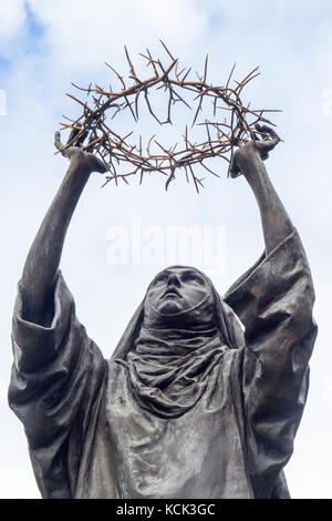 Statue en bronze de sainte Catherine de Sienne tenant une couronne d'épines. Banque D'Images