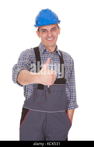 Heureux travailleur homme showing thumb-up sign over white background Banque D'Images