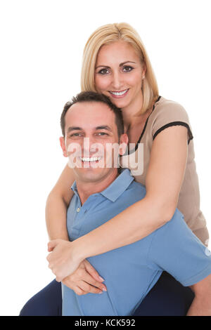 Jeune homme Piggybacking Woman Over White Background Banque D'Images