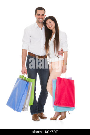 Jeune couple Holding Shopping Bag Over White Background Banque D'Images