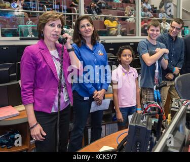 Ellen Ochoa, directrice du Centre spatial Johnson de la NASA (à gauche), et Nicole Stott, astronaute à la retraite de la NASA, aident de jeunes patients du MD Anderson Childrens cancer Hospital à parler à l'astronaute de la NASA Kate Rubins à bord de la Station spatiale internationale le 16 septembre 2016 à Houston, au Texas. (Photo de Robert Markowitz via Planetpix) Banque D'Images