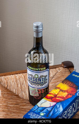 Bouteille d'absinthe et 'Van Gogh' illustré bouteille fort sur siège de chaise paille rustique Banque D'Images