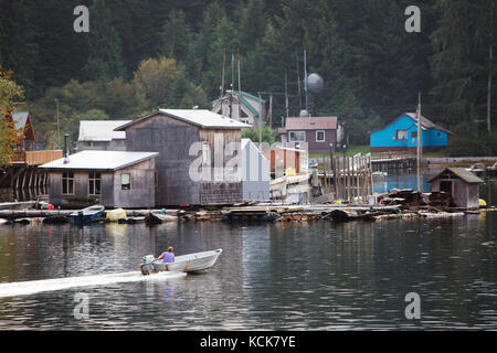 Une petite runabout se déplace le long de bâtiments flottants dans la petite communauté indigène de Kyuquot. Côte ouest de l'île de Vancouver, Colombie-Britannique, Canada Banque D'Images