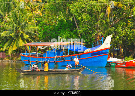 Canoë et bateaux de pêche amarrés dans l'eau dormante entre Kollam et Cochin, Kerala, Inde Banque D'Images