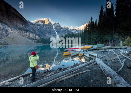Femme photographiant des canoës sur le lac Moraine, dans le parc national Banff, Alberta