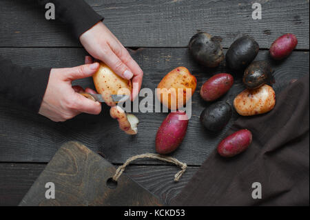 Femmes peler les pommes de terre fraîches Banque D'Images