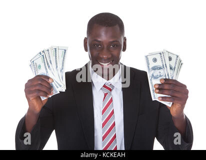 Portrait of young businessman holding billets sur fond blanc Banque D'Images