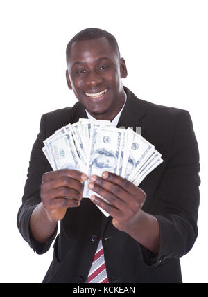 Portrait of young businessman holding billets sur fond blanc Banque D'Images