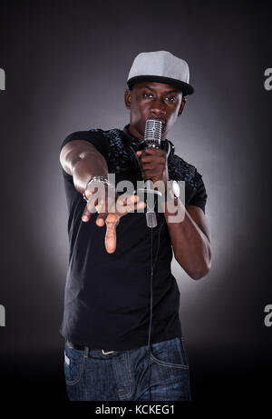 Portrait d'homme chantant chanteur hip-hop sur fond noir Banque D'Images