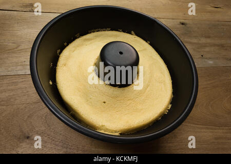 Gâteau de coton au café dans une poêle à gâteau en tube rond noire, prête à manger, sur une table en bois rustique, maison Banque D'Images