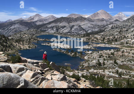 Randonneur s'arrête pour regarder Marie Lacs de Selden passer le long de la John Muir Trail dans la Sierra Nevada en Californie Banque D'Images