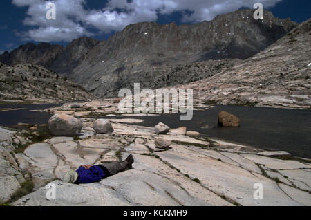 Randonneur prend un arrêt de repos à côté d'évolution Creek le long de la John Muir trail dans la sierra Nevada en Californie Banque D'Images