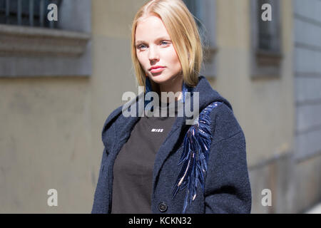 Milan, Italie - 22 septembre 2017 : mannequin blonde portant un t-shirt noir et une veste de femme bleue pendant le défilé Krizia, photographié dans la rue Banque D'Images