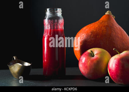 Sauce aux canneberges dans une bouteille, la citrouille et les pommes sur une table horizontale vue latérale Banque D'Images