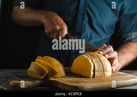 Couteau de cuisine coupe la moitié d'un moulin sur une planche en bois close-up l'horizontale Banque D'Images