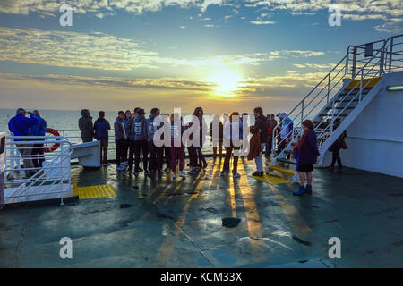 Foule d'étudiants au coucher du soleil sur la mer du Nord en bateau-ferry Banque D'Images