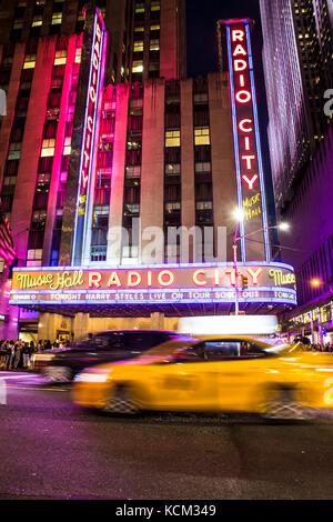 New York City, New York, USA - 28 septembre 2017 : avis de Radio City Music Hall à Manhattan vu la nuit avec les lumières, les voitures, taxis et harry styles Banque D'Images