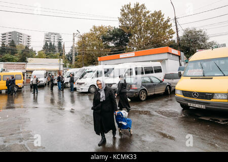 Tbilissi, Géorgie - 24 octobre 2016 : femme marche près de taxis urbains minibus est sur la gare didube à Tbilissi (Géorgie). Banque D'Images