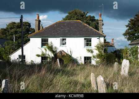 Le cimetière de l'église Saint-Michel d'en face d'une grande maison blanche dans le village de Amberley dans le West Sussex, Angleterre, Royaume-Uni. Banque D'Images