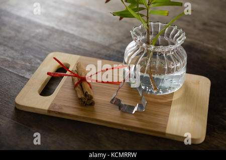 Close-up de cinnamons, emporte-pièce et de plantes en pot sur planche à découper Banque D'Images