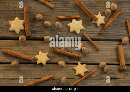 Star shape cookies et des bâtons de cannelle avec les noix sur la table en bois Banque D'Images