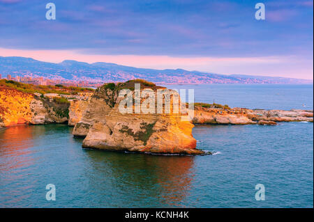 Magnifique coucher de soleil sur le raouche, pigeons' rock. à Beyrouth, Liban.sun et les pierres se reflètent dans l'eau.des nuages denses dans le ciel. Banque D'Images