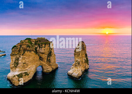 Magnifique coucher de soleil sur le raouche, pigeons' rock. à Beyrouth, Liban.sun et les pierres se reflètent dans l'eau.des nuages denses dans le ciel. Banque D'Images