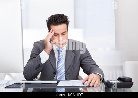 Portrait of a souligné businessman sitting at desk Banque D'Images