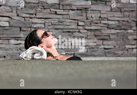 Une femme mature se détend dans un bain à remous tout en visitant le Kingfisher Resort et Spa. Courtenay, l'île de Vancouver, Colombie-Britannique, Canada. Banque D'Images