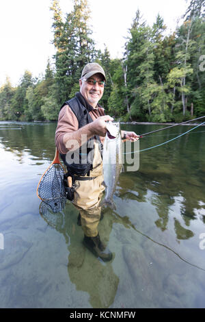 Un fier pêcheur de mouche affiche ses prises pendant la pêche la rivière Campbell, l'île de Vancouver. Banque D'Images