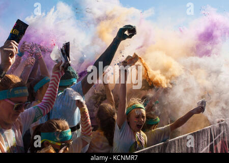 Hampton, GA, USA - 2 avril 2016 : une foule de coureurs qui ont terminé dans la color run, mélanger des paquets d'amidon de maïs de couleur dans l'air à Atlanta, GA. Banque D'Images