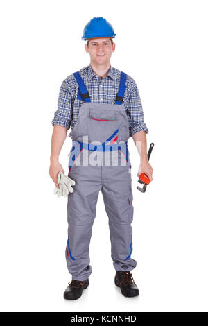 Smiling handsome handyman dans travailler avec l'outil isolé sur fond blanc Banque D'Images