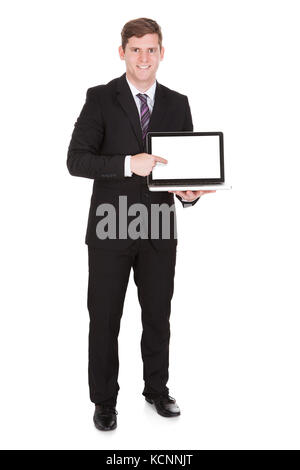 Portrait of businessman pointing sur ordinateur portable isolé sur fond blanc Banque D'Images