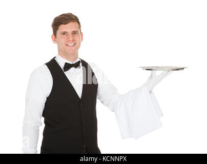 Waiter holding empty silver tray sur fond blanc Banque D'Images