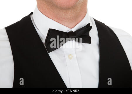 Portrait d'un homme vêtu d'un costume avec papillon sur fond blanc Banque D'Images