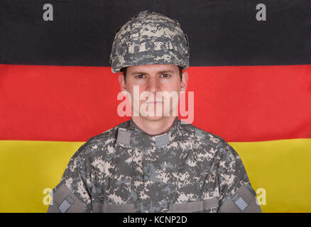 Portrait de soldat grave debout devant Drapeau allemand Banque D'Images