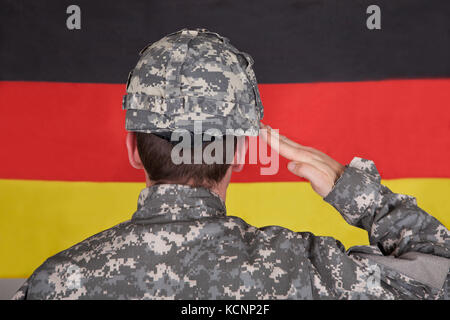 Portrait de soldat grave debout devant Drapeau allemand Banque D'Images