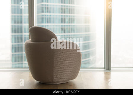 Bureau moderne avec chaise designer vide près de big sur toute la longueur de la fenêtre panoramique en verre et gratte-ciel de la ville urbaine à l'extérieur, le luxe apartm contemporain Banque D'Images