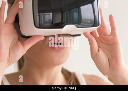 Jeune femme surprise première fois essayer casque vr, étonné girl film 3D lunettes de réalité virtuelle en tournée, j'en croire ses yeux, faire l'expérience de Banque D'Images