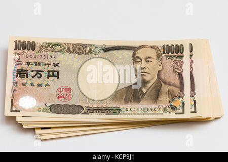 Billets en japonais. Pile de 10 000 Yen notes sur fond blanc. Banque D'Images