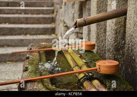 Fontaine japonaise et de bambous louches utilisée pour le lavage des mains à l'entrée du sanctuaire shimogamo-jinja à Kyoto Banque D'Images