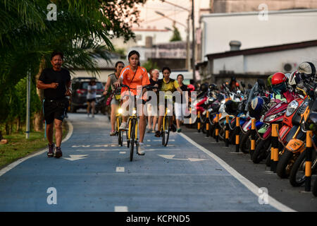 Phuket, Thaïlande. 5 octobre 2017. Les résidents locaux roulent ofo partageant des vélos sur une piste cyclable dans un parc public à Phuket, Thaïlande, Oct. 5, 2017. La société chinoise de partage de vélos sans quai ofo a fourni plus de 1 000 vélos dans les endroits clés de Phuket fin septembre et a offert un essai gratuit d'un mois sans frais de dépôt. Maintenant, le service de partage de vélos a profité aux résidents locaux et aux touristes. Les frais de service réguliers d'OFO seront facturés à 5 Baht par 30 minutes d'utilisation, avec des frais de dépôt de 99 Baht. Crédit : Li Mangmang/Xinhua/Alamy Live News Banque D'Images