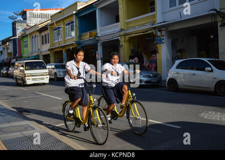 Phuket, Thaïlande. 5 octobre 2017. Des étudiants locaux montent ofo partageant des vélos dans une zone commerciale de Phuket, Thaïlande, Oct. 5, 2017. La société chinoise de partage de vélos sans quai ofo a fourni plus de 1 000 vélos dans les endroits clés de Phuket fin septembre et a offert un essai gratuit d'un mois sans frais de dépôt. Maintenant, le service de partage de vélos a profité aux résidents locaux et aux touristes. Les frais de service réguliers d'OFO seront facturés à 5 Baht par 30 minutes d'utilisation, avec des frais de dépôt de 99 Baht. Crédit : Li Mangmang/Xinhua/Alamy Live News Banque D'Images