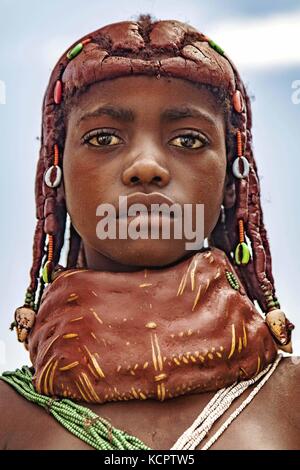L'Angola. Mar 20, 2013. 20 mars 2013 - Angola - Mwila girl (également appelé Mwela, Mumuhuila Muhuila ou). Mwila femmes sont célèbres pour leurs coiffures très orné, qui sont maintenus en place à l'aide d'un mélange de boue ocre, du fumier de bovins et de beurre. La tradition veut que lorsqu'une fille est prépubère, elle porte un collier rouge massif qui deviendra plus tard devenir un jaune - l'vikeka. Elle est donnée le vikeka quand elle reçoit sa première période. Une fois qu'elle est mariée, elle porte un ensemble de colliers appelé le vilanda, qu'elle ne pourra plus jamais décoller. Une fois mis sur, itÃ¢â€™impossible de décoller, avec nous Banque D'Images