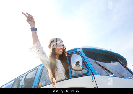 Femme hippie heureux montrant la paix en voiture fourgonnette Banque D'Images