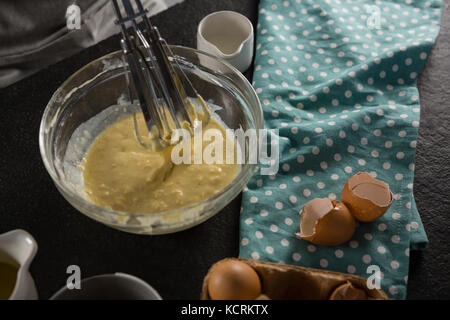 Close-up de fraîchement battu pâte d'oeufs battus, le lait et le beurre dans un bol Banque D'Images