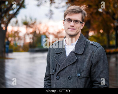 Portrait de jeune homme confiant avec succès dans la ville. homme dans un costume d'affaires et des verres dans la rue de l'automne. portrait de beau mec. Banque D'Images