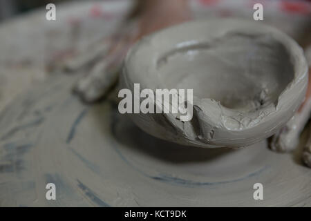 Close-up de mains d'un moulage de fille d'argile dans atelier de poterie Banque D'Images