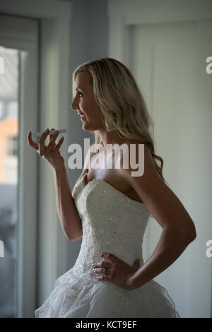 Beautiful Woman talking on mobile phone at home Banque D'Images